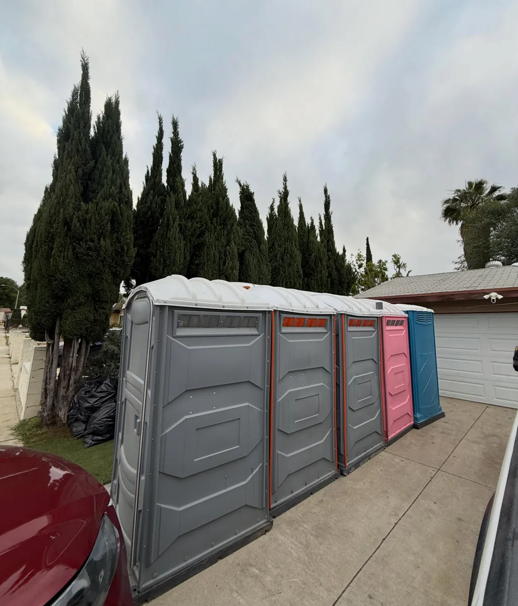 Wide portable restroom units beside standard units